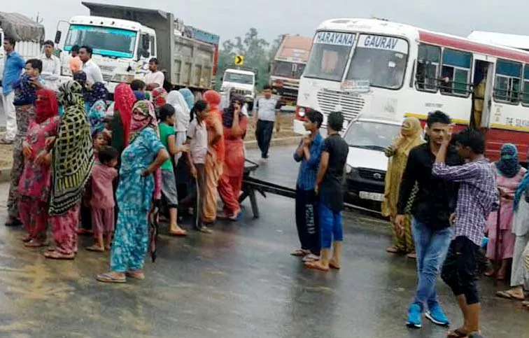 बरसात में हिसार-चंडीगढ़ हाइवे पर बैठे ग्रामीण