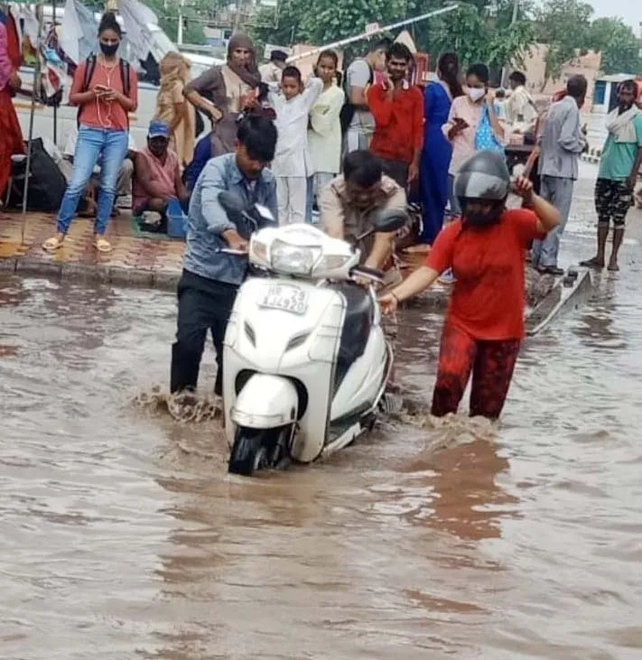 बारिश में सड़क पर बन्द हुई मोटरकार, पुलिसकर्मियों ने धक्का दे निकाली बाहर