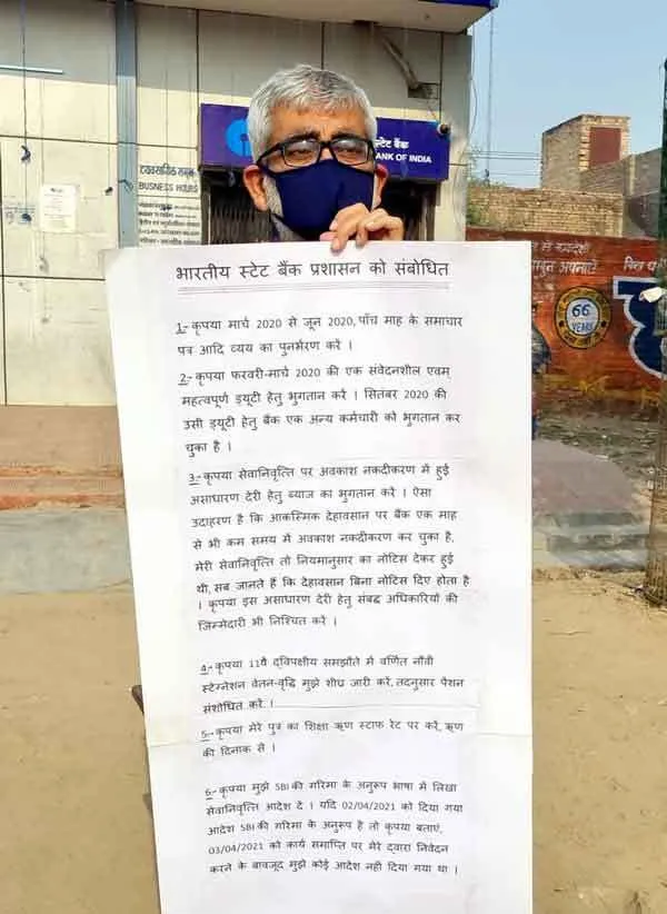 मांगों के बैनर सहित बैंक के सामने हुआ खड़ा
