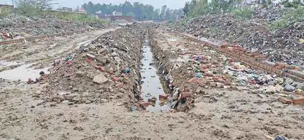 कूड़े के ढेर पर रास्ता बनाने के खिलाफ लोगों में रोष