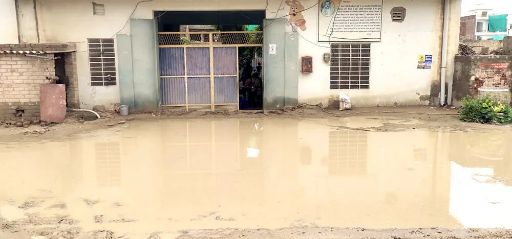 बारिश से गलियों में भरा पानी, गड्ढे में फंसी कार
