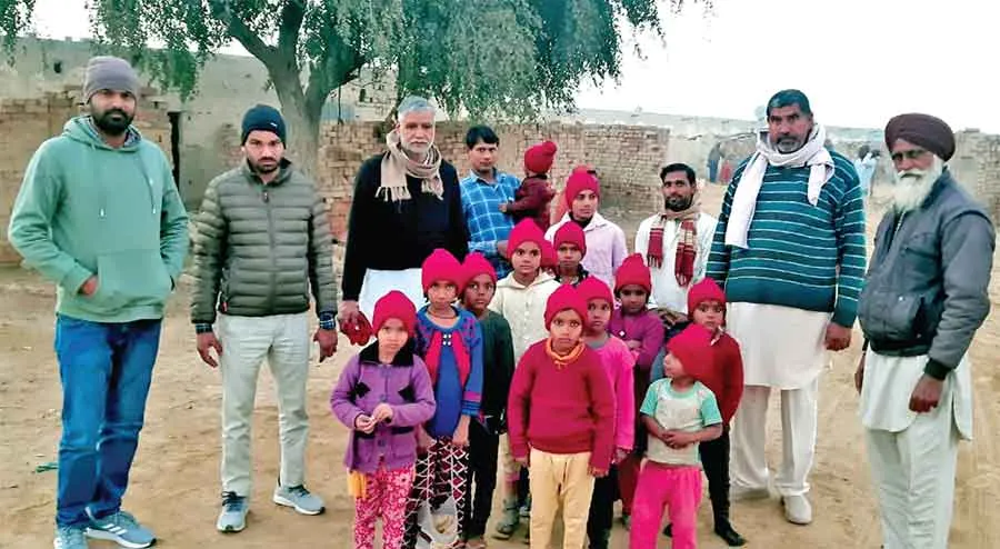 श्रीगुरूसर मोडिया की साध-संगत ने बच्चों को बांटी गर्म टोपियां व जुराबें