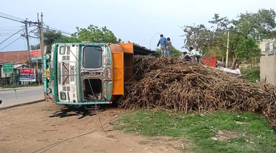 गन्ने से लदा ट्रक हाईवे किनारे लगे विद्युत पोल को तोड़ते हुए पलटा, टला बड़ा हादसा