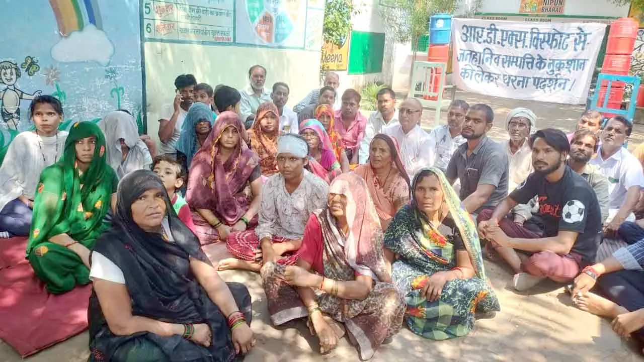 मुआवजा राशि बढ़ाने की मांग को लेकर धरने पर बैठे लोग