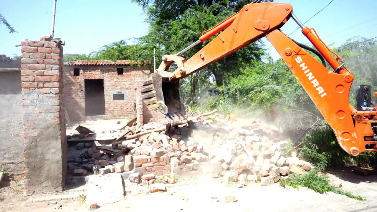 Bulldozer: तस्कर की अवैध संपत्ति पर चला बुलडोजर