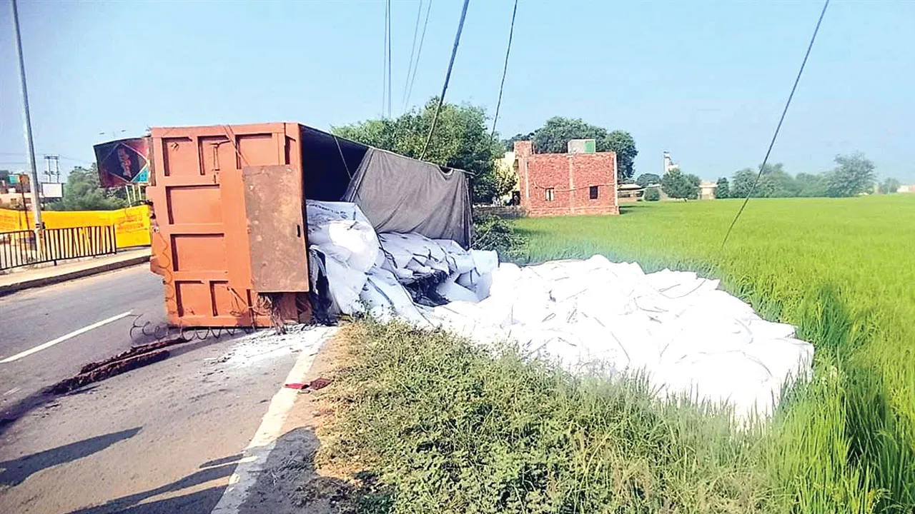 Truck Road Accident: हुक टूटने से नमक से भरा ट्राला पलटा, बिजली की तारें टूटीं