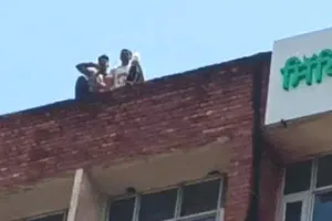 शिक्षा बोर्ड की ऊपरी मंजिल पर चढ़े दो युवक