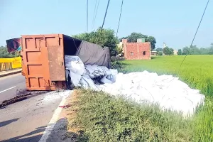 Truck Road Accident: हुक टूटने से नमक से भरा ट्राला पलटा, बिजली की तारें टूटीं