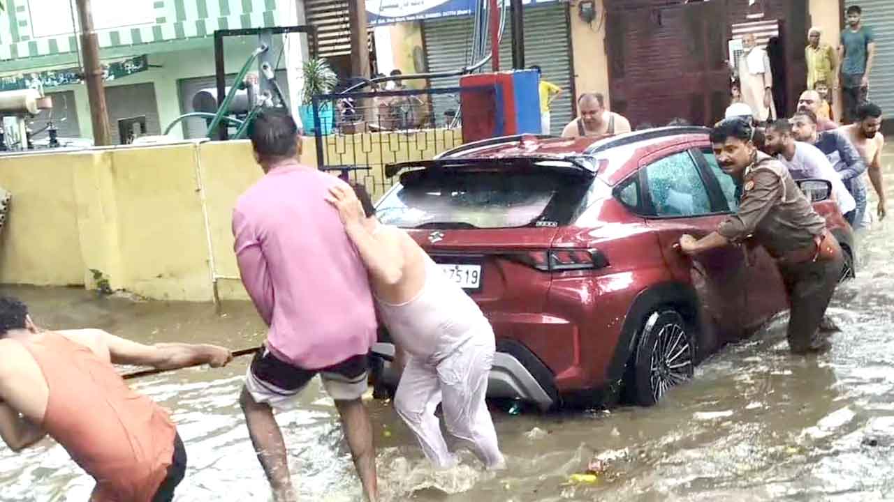 बारिश के पानी में बहने लगी कार, पुलिसकर्मियों ने परिवार को किया रेस्क्यू