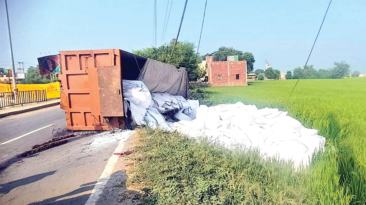 Truck Road Accident: हुक टूटने से नमक से भरा ट्राला पलटा, बिजली की तारें टूटीं